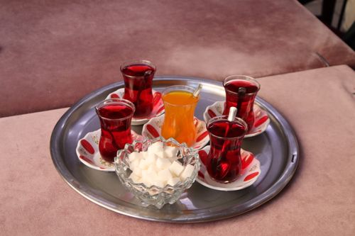 Free A traditional Turkish tea set with red tea, orange juice, sugar cubes on a tray, indoors. Stock Photo