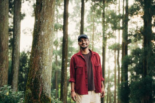 Free A young man enjoys a peaceful moment in a lush, idyllic forest landscape. Stock Photo