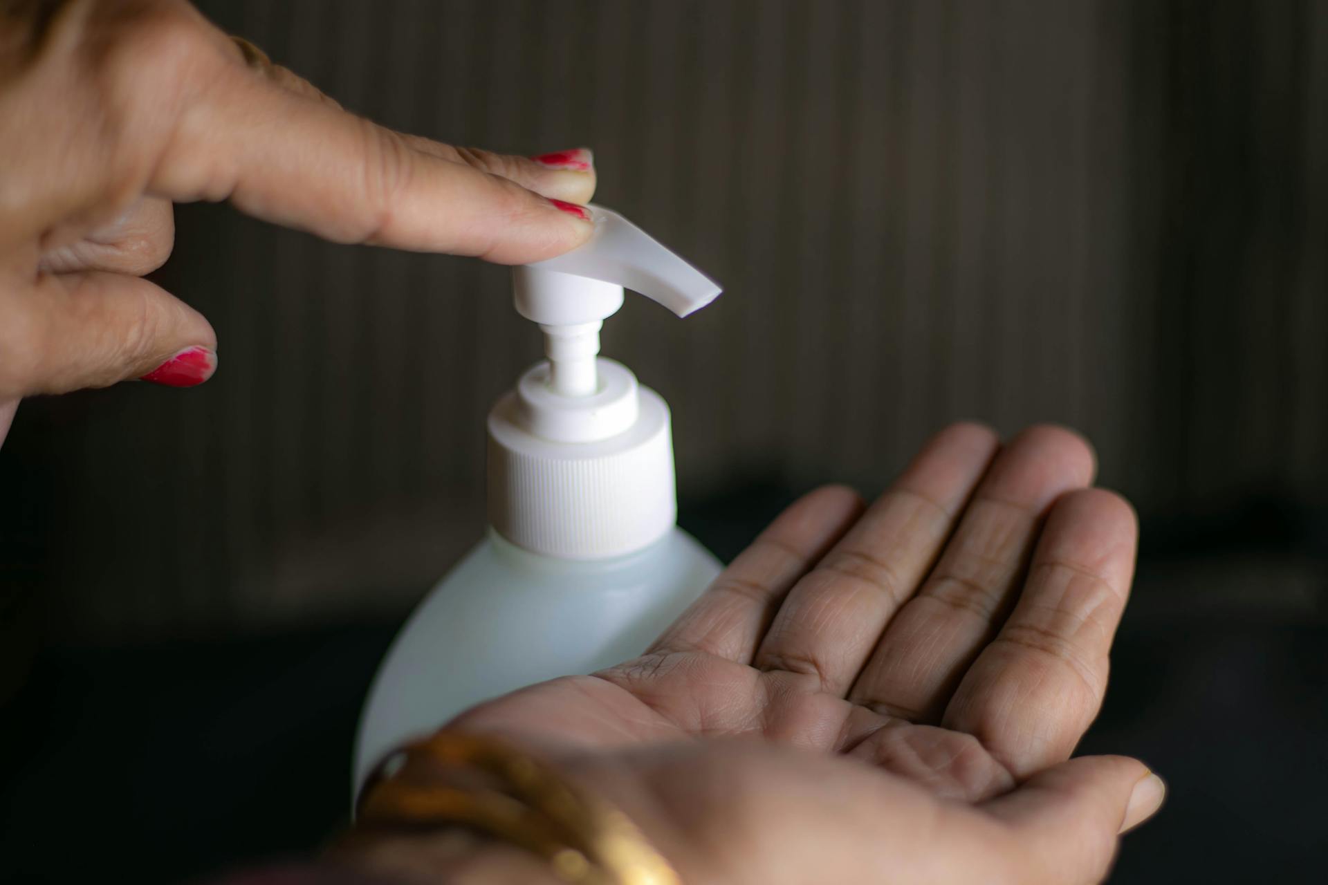 Person Holding White Plastic Pump Bottle