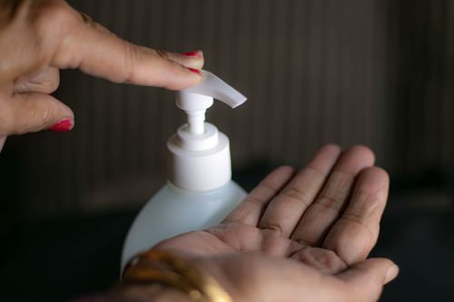 Free Close-up shot of hand using a sanitizer pump indoors, promoting hygiene practices. Stock Photo