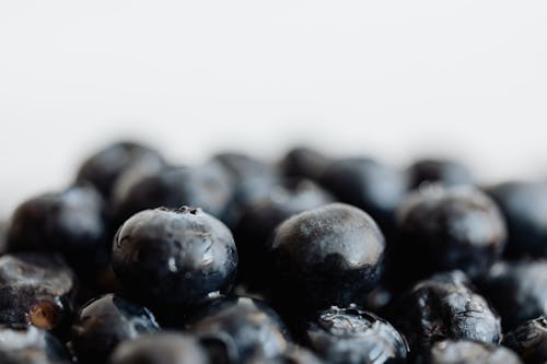 Closeup bunch of ripe delicious fresh ripe blueberries placed on white surface