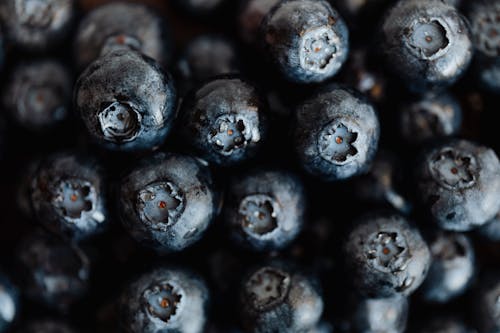 Closeup bunch of fresh delicious and sweet blueberries placed on counter of supermarket