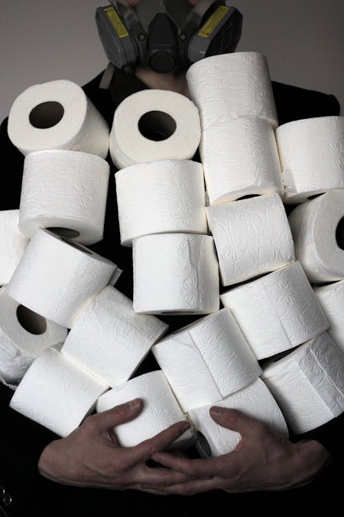 Free Person Carrying Pile of Tissue Rolls Stock Photo