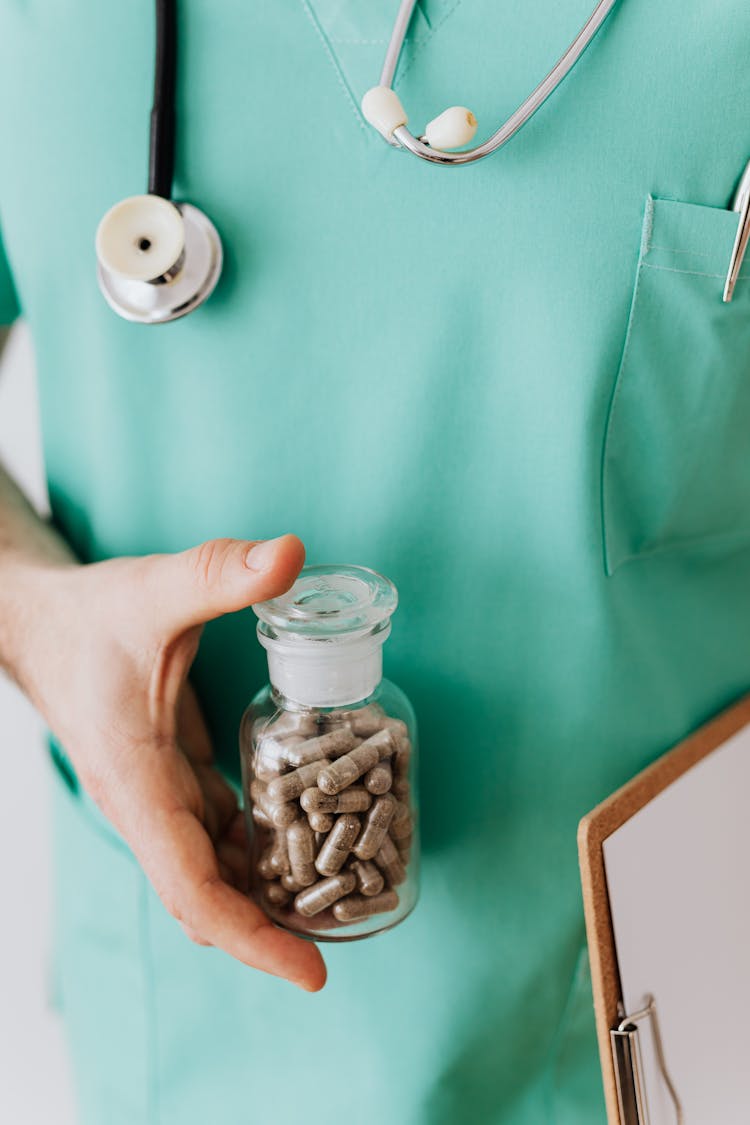 Crop Male Doctor With Vial Of Pills And Stethoscope