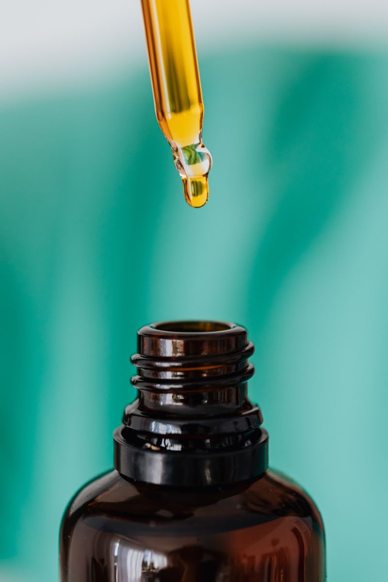 Amber dropper bottle with a drop of treatment oil