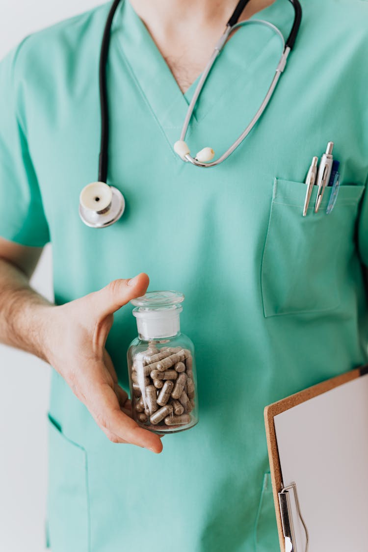 Unrecognizable Man Showing Vial With Pills For Patient