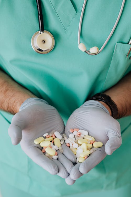 Free Crop man doctor showing pills in clinic Stock Photo