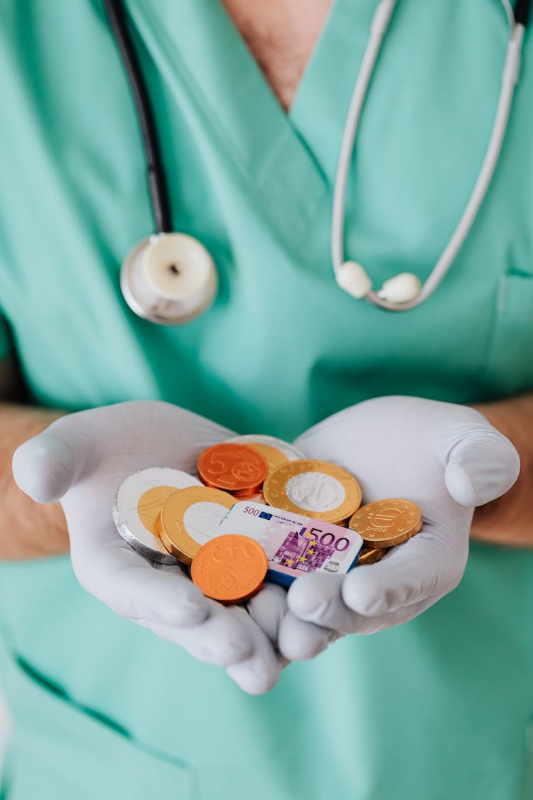 Anonymous Medical Worker With Chocolate Coins In Hands