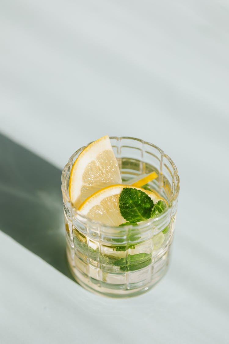 Glass Of Alcohol Cocktail On White Surface