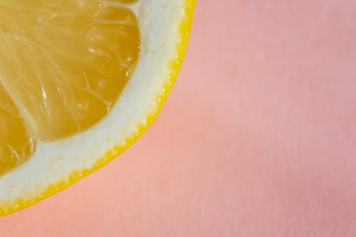 Quarter of lemon on pink background