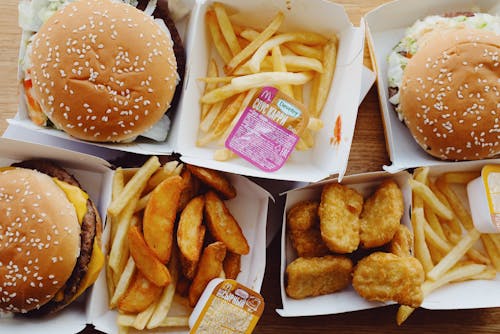 Flat lay top view of various appetizing fast food consisting of burgers and french fries