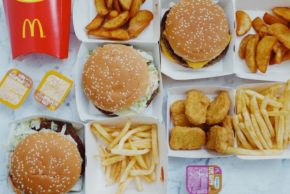 Free Top view flat lay of junk food including burgers with french fries and nuggets placed on marble table Stock Photo