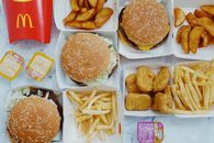 Top view flat lay of junk food including burgers with french fries and nuggets placed on marble table