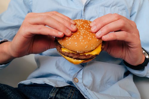 Free Delicious burger in hands of unrecognizable man Stock Photo