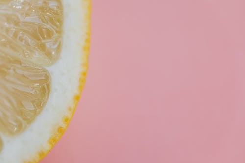 Top view flat lay composition of sliced lemon placed on pink background