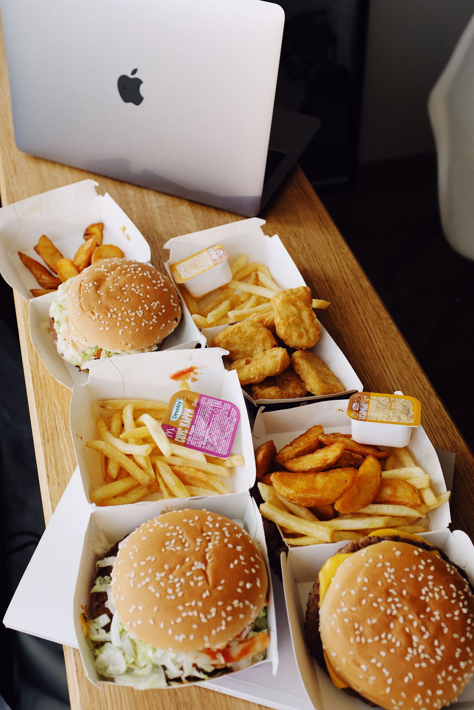 Fast food meal beside a laptop on a table.