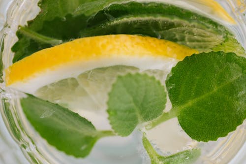 Closeup top view of nonalcoholic drink made of slices of lemon and leaves of mint