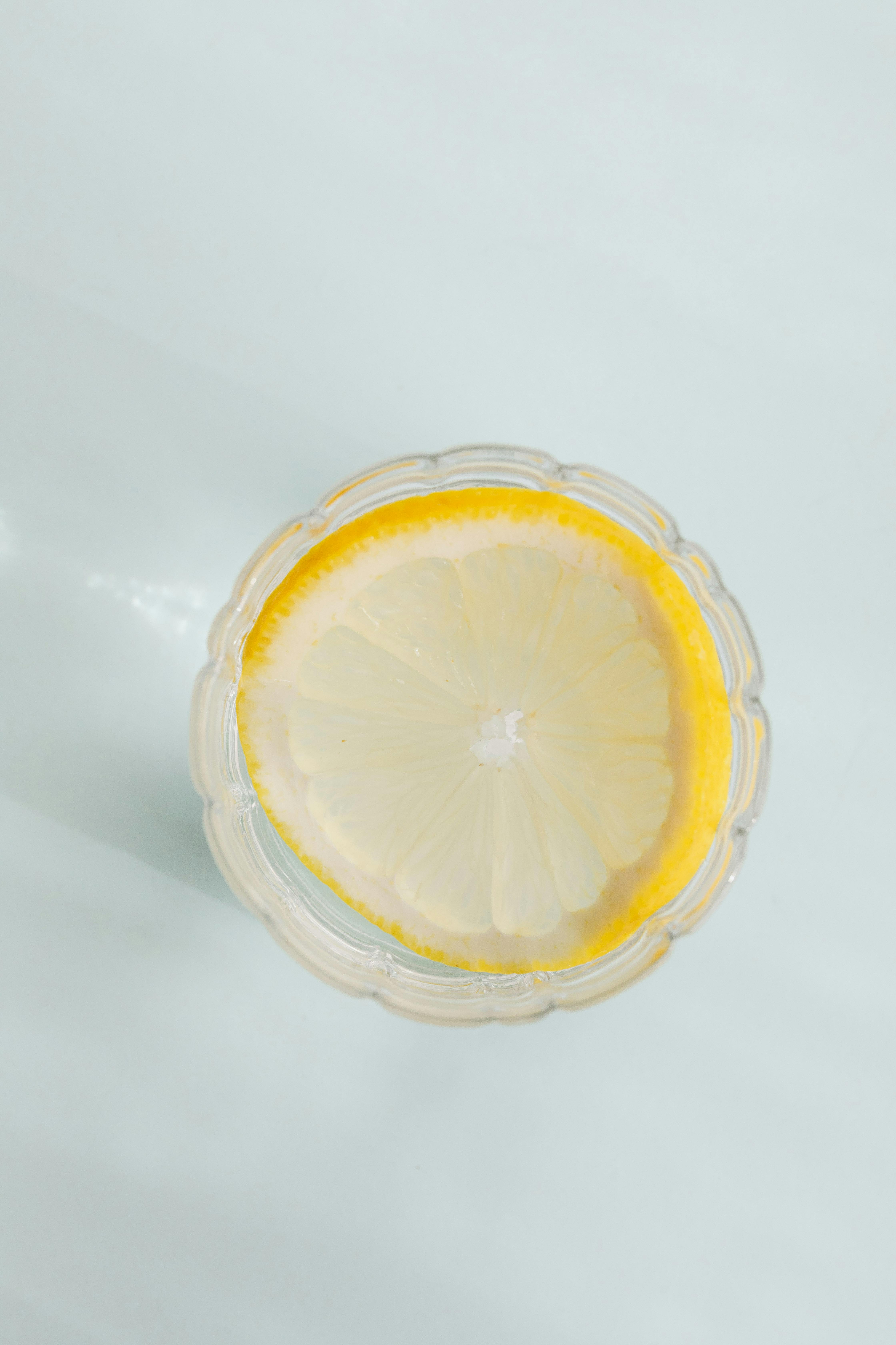 glass with lemon drink on white background