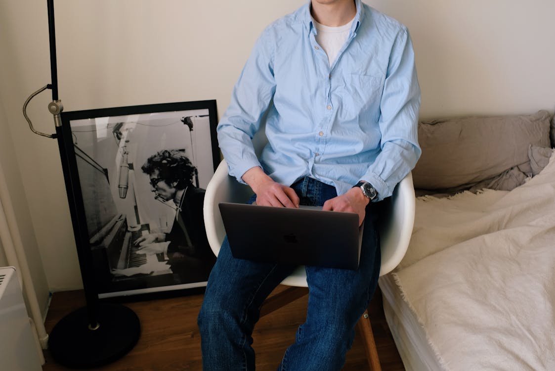 Free Crop man using laptop in room Stock Photo