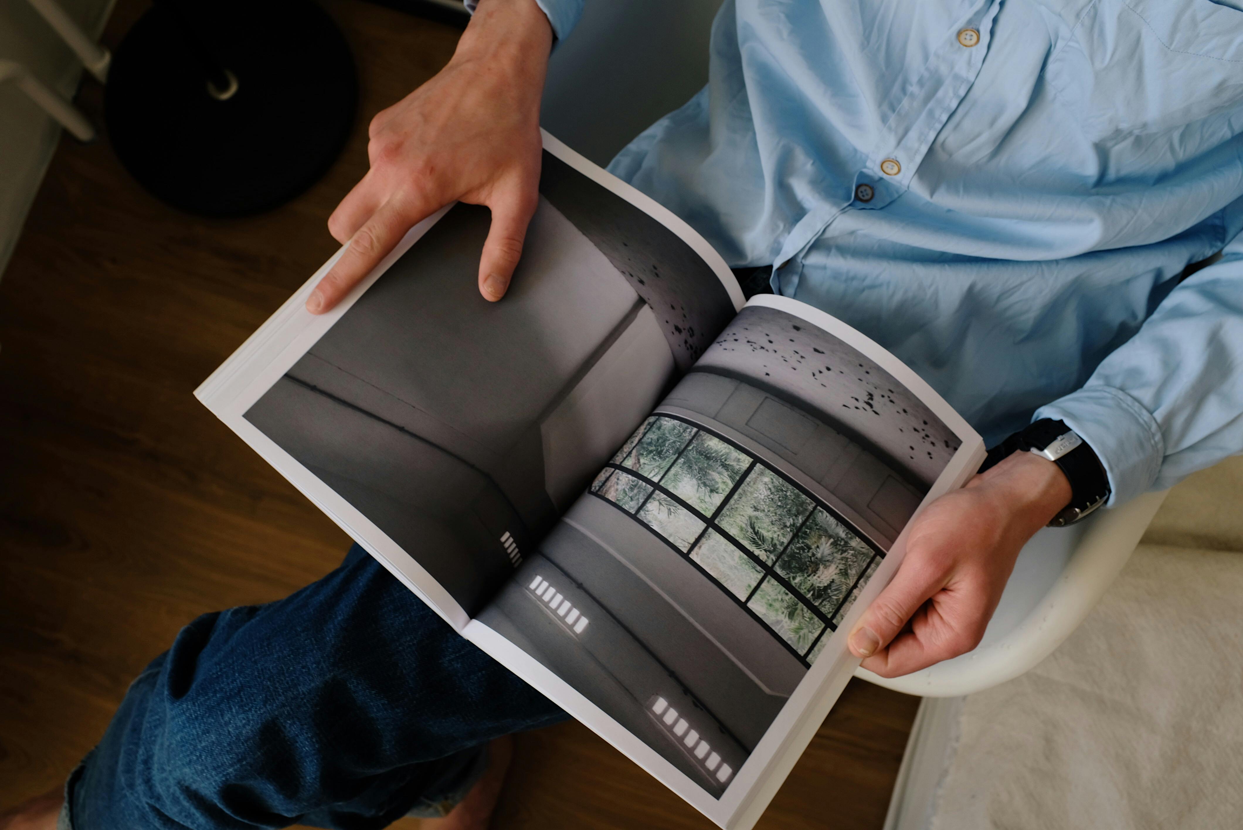 faceless man examining book in modern workspace