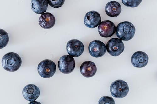 Free Top view of delicious ripe and sweet blueberry randomly scattered on white surface Stock Photo