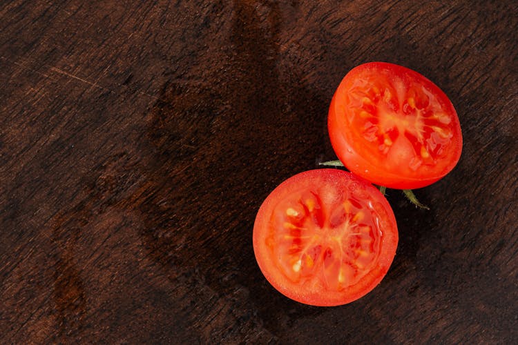 Appetizing Juicy Halves Of Tomato On Wooden Table