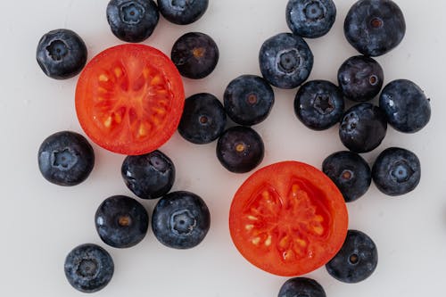 Halves of tomato and scattered blueberries