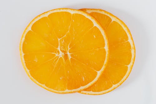 Free Top view closeup of cut round slices of fresh orange on white background Stock Photo