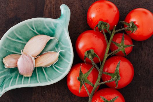 Tomatoes and plate of cloves on table