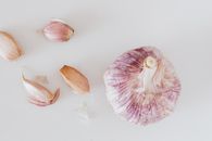 From above closeup of big whole garlic and set of cloves placed on white surface