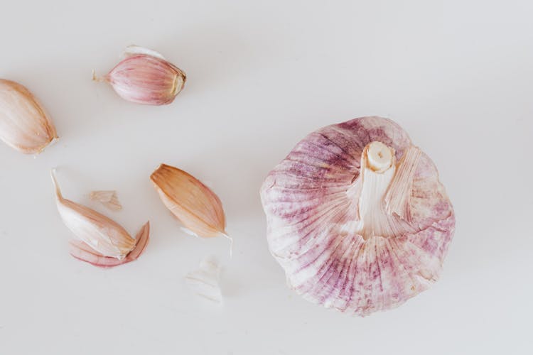 Garlic And Cloves On White Surface