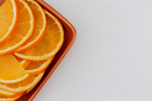 Minimalistic layout of fresh orange slices on ceramic rectangular plate