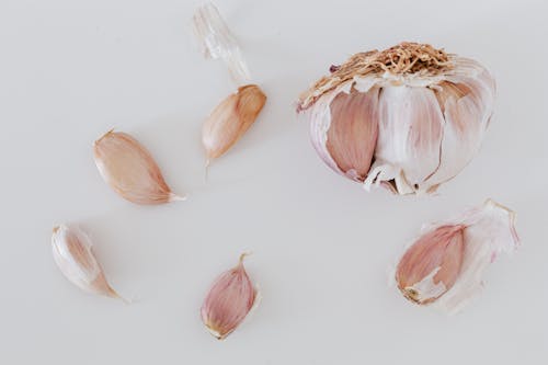Top view of process separation of garlic cloves before cooking placed on gray background