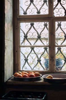 Warm natural light on apples and oranges by a vintage window in Zittau, Germany.