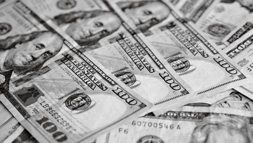 Free A close-up black and white view of US one hundred dollar bills scattered together. Stock Photo