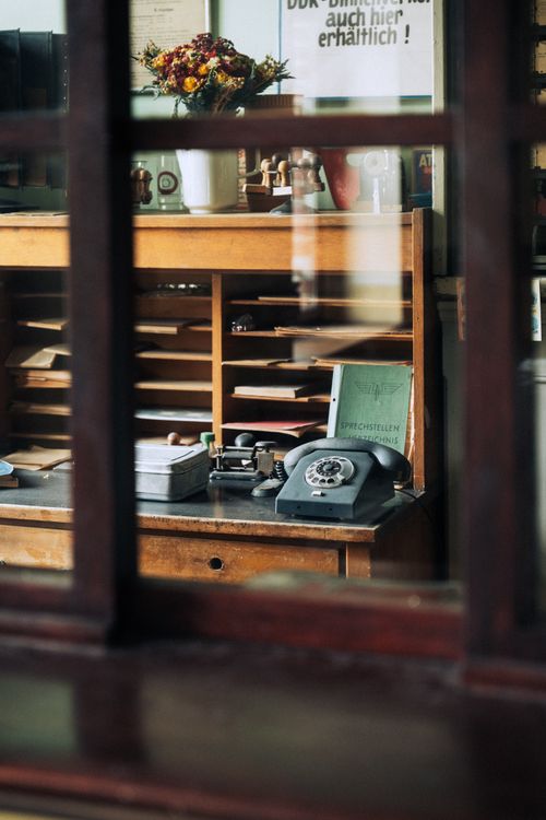 Free Cozy vintage office scene with a rotary phone and wooden desk. Stock Photo