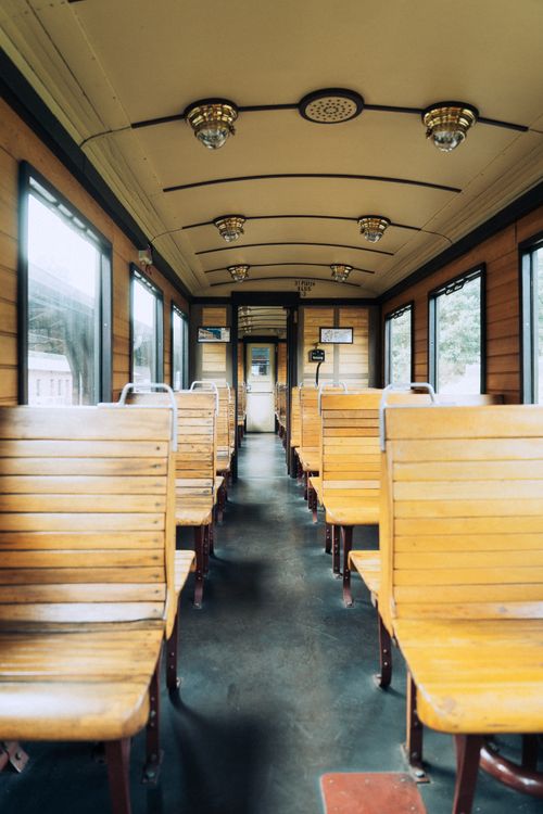 Free Explore the charm of a vintage wooden train car interior with empty wooden seats and windows. Stock Photo