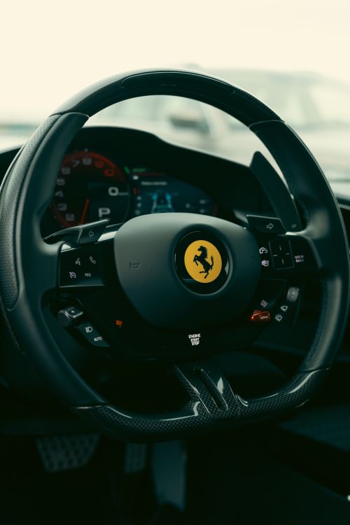 Free Detailed view of a Ferrari steering wheel showcasing luxury design and technology. Stock Photo