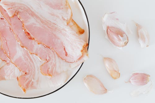 Composition of bacon and garlic on desk