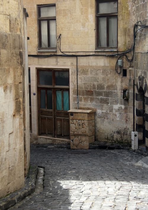 Free A serene view of a narrow stone alleyway with rustic architecture in a historic town. Stock Photo