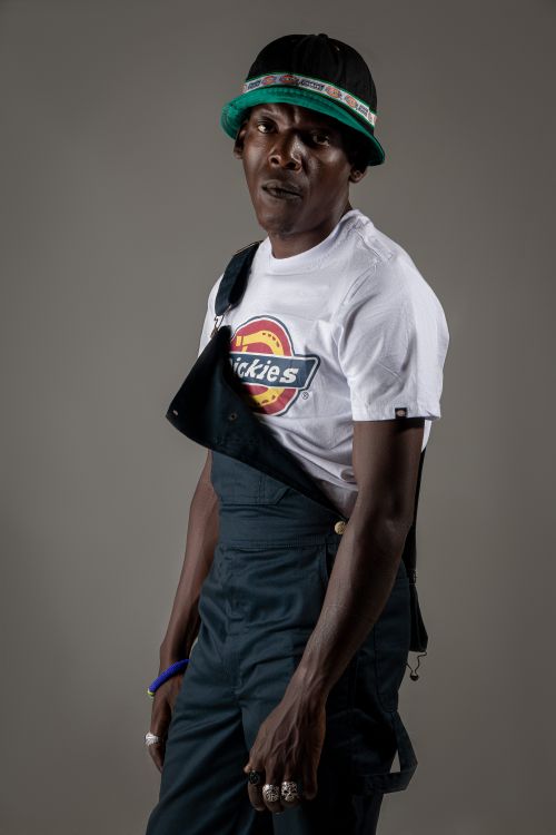 Free A man poses confidently in a trendy outfit with a branded t-shirt and hat. Stock Photo