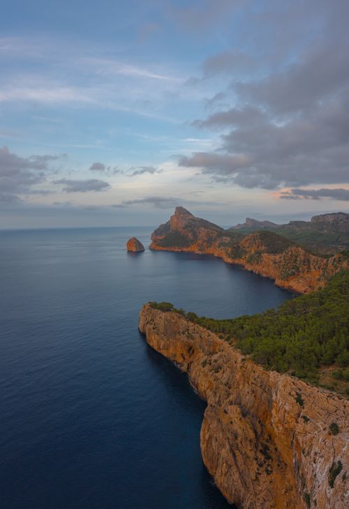 Free Breathtaking aerial view of Cala Llentia in Ibiza at twilight, showcasing the rocky coastline and serene sea. Stock Photo
