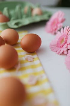 黄色格子布上，棕色鸡蛋与粉色花朵相映成趣，唤起了清新的春日气息