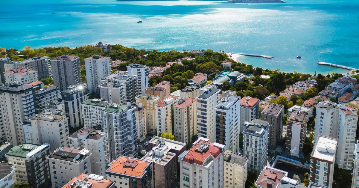 Stunning aerial view of Istanbul's coastal skyline with city buildings and blue sea under a clear sky.