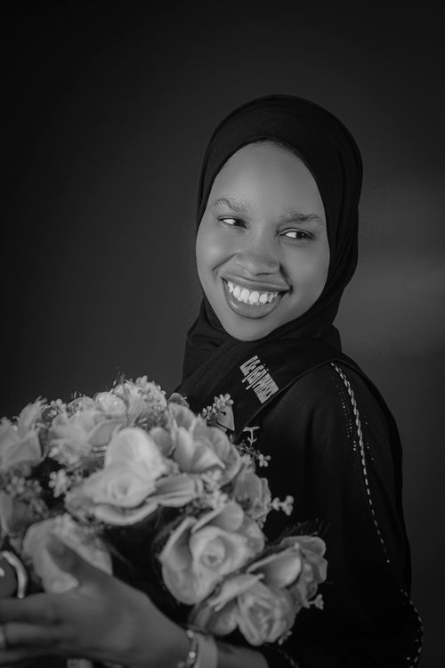 Free Black and white portrait of a smiling woman holding a floral bouquet. Stock Photo