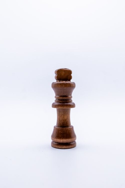 Free Minimalist photo of a wooden chess king piece against a plain white background. Stock Photo