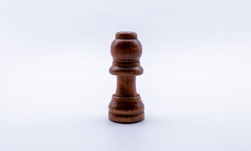 Free Close-up of a wooden chess piece with a minimalist white background. Stock Photo