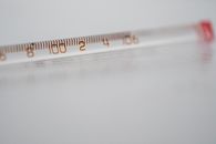 白色表面上，汞玻璃温度计的特写清晰显示了温度测量结果