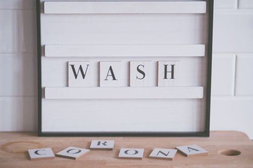Free Letters forming words WASH and CORONA arranged on wooden counter in bathroom representing coronavirus prevention concept Stock Photo