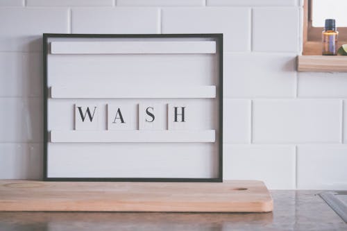 Signboard with word WASH in bathroom